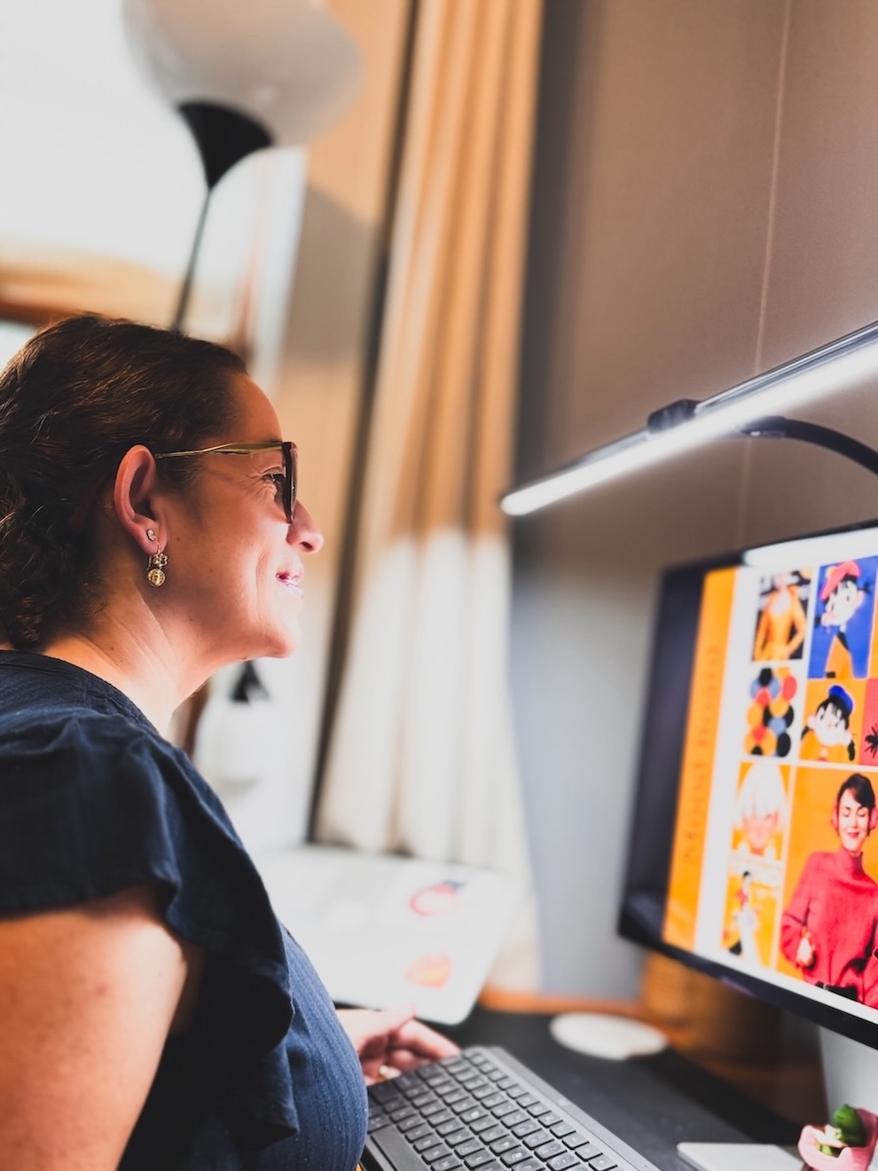 Leonor Jimenez working at her desk, reviewing website illustration mockups on screen